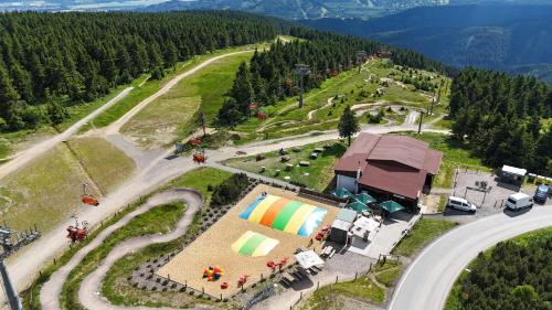 an aerial view of a farm with a building and a road at Kalahari Klínovec in Loučná pod Klínovcem