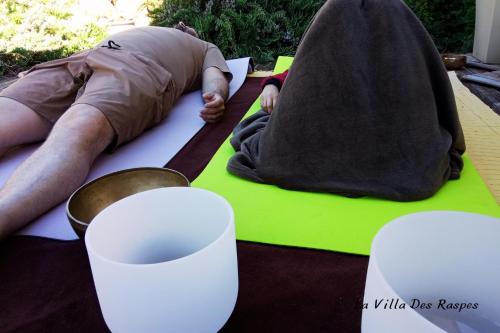 a man laying on a table with two styrofoam cups at La Villa Des Raspes - Séjour Spa - Adult Only in Viala-du-Tarn