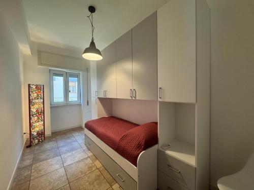a bedroom with a bed with a red blanket at CASA Degli ARTISTI in Acilia