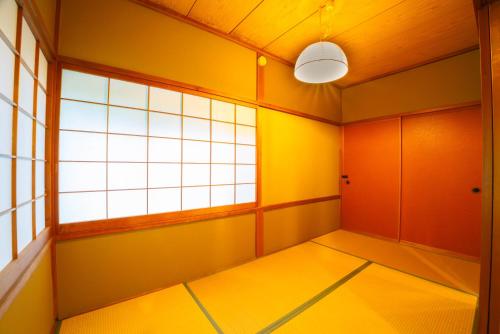 an empty room with yellow and orange walls and a window at クラレンス-森の中でBBQと4Kプロジェクターが楽しめる北軽井沢の貸切Villa- in Kita-karuizawa