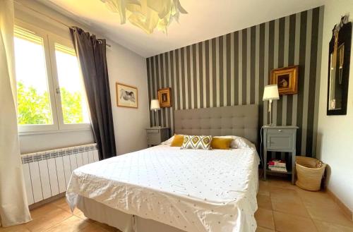 une chambre avec un lit blanc et une fenêtre dans l'établissement Les Oliviers - Ceyreste, à Ceyreste