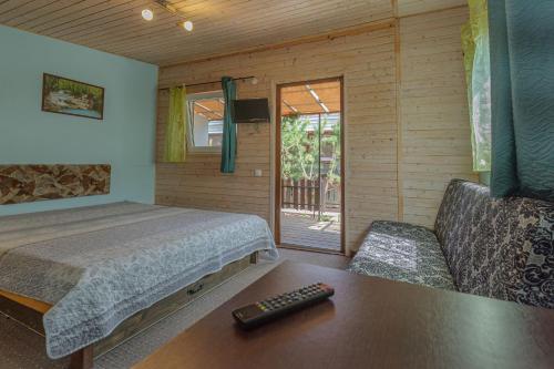 a bedroom with a bed and a couch and a table at Pylimo slėnis in Palanga