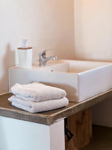 a bathroom with a sink and towels on a counter at Quinta Luz do Sol in Moncarapacho