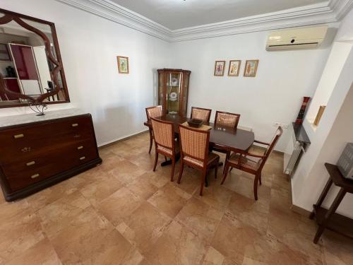 a dining room with a table and chairs and a mirror at Monastir duplex with terrace in the marina in Monastir