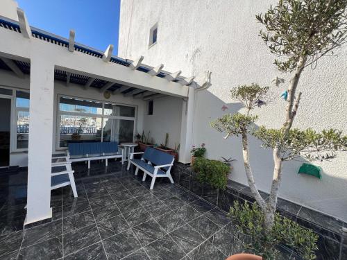 a patio with chairs and a table and a building at Monastir duplex with terrace in the marina in Monastir