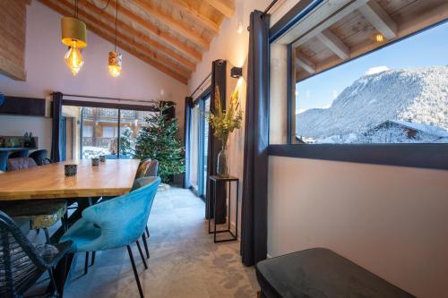 une salle à manger avec une table et une grande fenêtre dans l'établissement Simply Morzine - Chalet Stade, à Morzine