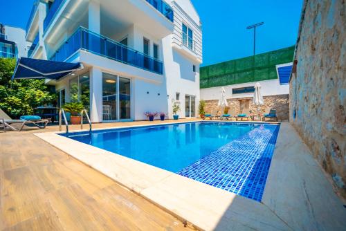 a swimming pool in front of a house at Mavi Ruya - Modern ground floor duplex apartement with private pool & XL outdoor in Kalkan