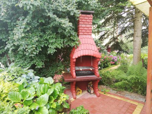a small red brick oven sitting in a garden at Domek Piaski Nad Morzem in Krynica Morska