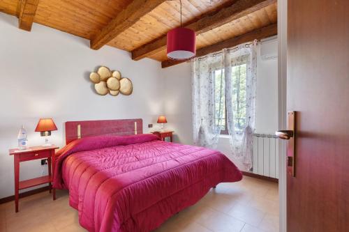 a bedroom with a pink bed and a window at Il Serraglio Rooms in Valeggio sul Mincio