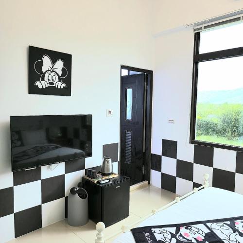 a room with a black and white checkered wall at Snail B&B in Pinghe