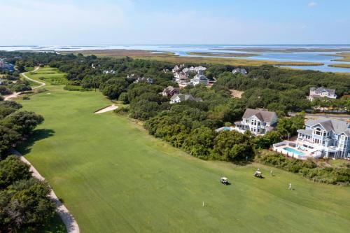 an aerial view of a golf course with houses at Beach ParTee Time in Corolla