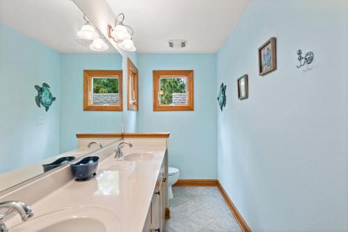 a bathroom with two sinks and a toilet at Beach ParTee Time in Corolla