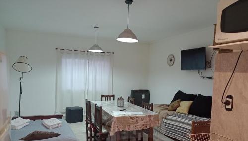 ein Wohnzimmer mit Tisch und Couch in der Unterkunft Alquiler Temporario CF in San Carlos de Bolívar
