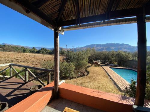 a view from the porch of a house with a swimming pool at Sani Lodge & Cottages in Sani Pass