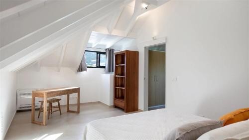 a bedroom with a bed and a desk in a room at Lovely Villa In A Private And Tropical Atmosphere in Quartier de Lorient