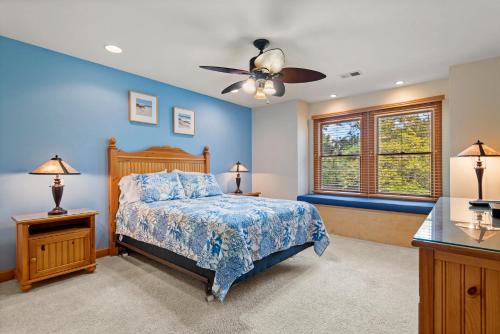 a blue bedroom with a bed and a ceiling fan at Beach ParTee Time in Corolla