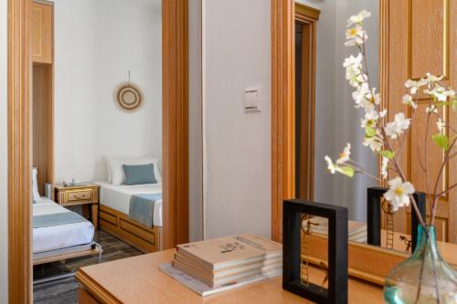 a room with a bed and a desk with a mirror at EVLOGIA HOTEL SEAFRONT and ANEX by Greek Pride in Fourka