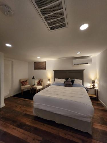 a bedroom with a large white bed and two chairs at HomeSmart: Cozy Charm Meets High-Tech in Prime Area in Seattle