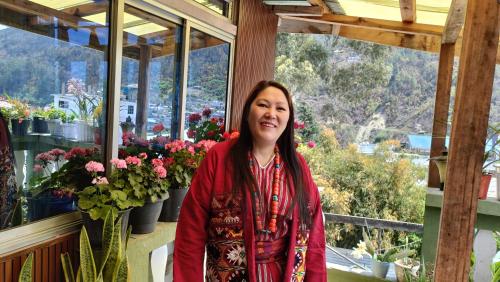 a woman standing in front of a flower shop at Khowti Stay in Dirang Dzong