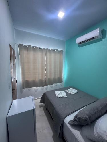 a blue room with a bed and a window at Lençóis House in Barreirinhas