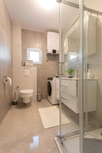 a bathroom with a toilet and a washing machine at VILLA PADRE in Podstrana
