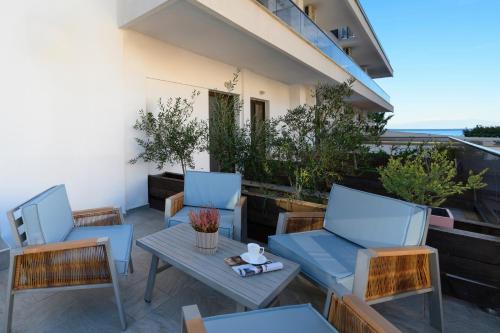 a patio with chairs and tables on a balcony at EVLOGIA HOTEL SEAFRONT and ANEX by Greek Pride in Fourka