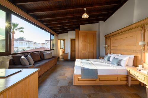 a bedroom with a large bed and a couch at EVLOGIA HOTEL SEAFRONT and ANEX by Greek Pride in Fourka