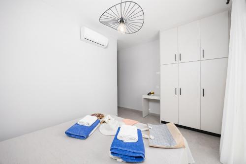 una stanza con armadi bianchi e asciugamani blu su un tavolo di Villa Tania Dio a Karavádhos