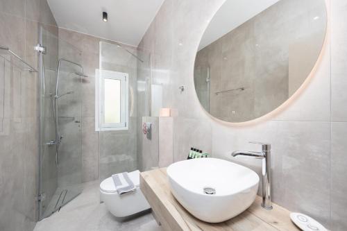 a white bathroom with a sink and a shower at Villa Tania Dio in Karavádhos