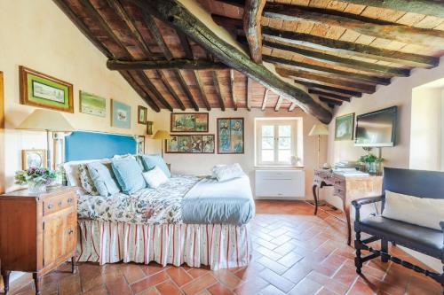 a bedroom with a bed and a desk in a room at Villa Morello Farmhouse in Lucca