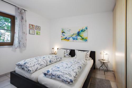 a bedroom with two beds and a painting on the wall at Unterm Nussbäumle in Adelhausen