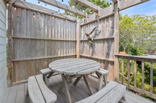 a wooden table and chairs on a wooden deck at Aloha on the Atlantic in Southern Shores