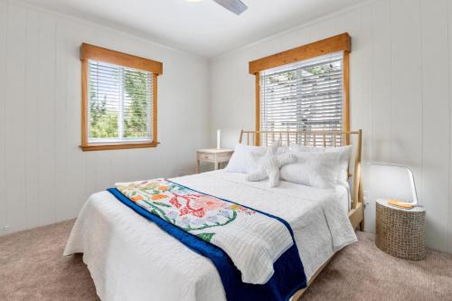 a white bedroom with a bed and a window at Aloha on the Atlantic in Southern Shores