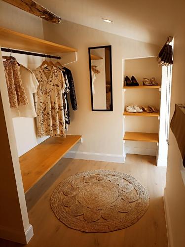 a hallway with a dressing room with a rug and a mirror at Au Petit Bonheur de Lorigné in Lorigné