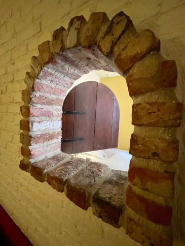 a brick wall with a wooden door in a room at City Flats by Lybeer Hotel Group in Bruges
