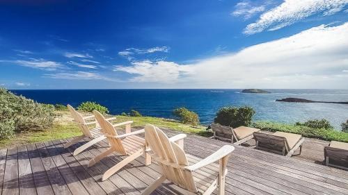 a deck with chairs and a view of the ocean at Pointe-Milou Ocean Oasis with Private Pool in Pointe Milou