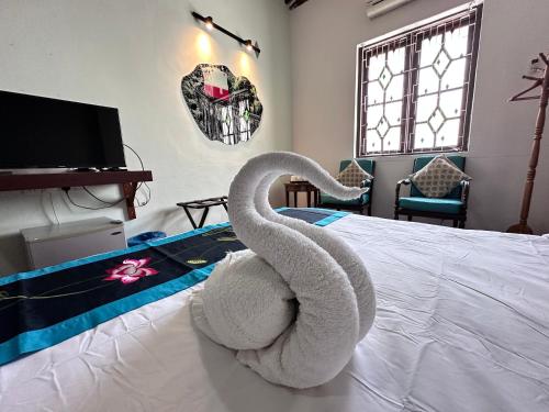 a towel swan sitting on top of a bed at 26 Rangoon Residence 26 in George Town