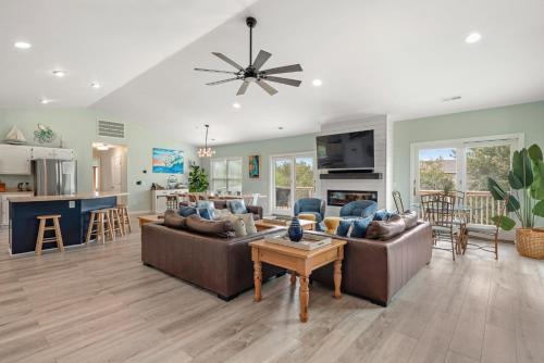 a living room with two couches and a kitchen at Aloha Shores in Southern Shores