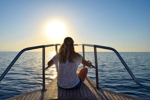 a woman sitting on a boat looking out at the ocean at B&B Dimora Nonna Isabella in Conversano