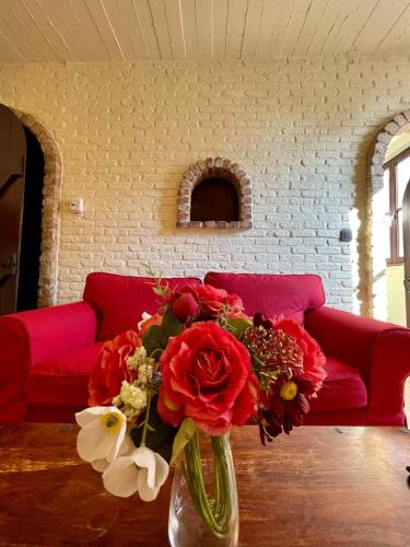 a vase filled with red flowers sitting on a table at City Flats by Lybeer Hotel Group in Bruges