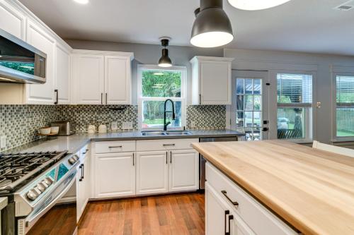 a kitchen with white cabinets and a wooden counter top at 6 Mi to Northshore Park Family Home with Pool! in Conroe