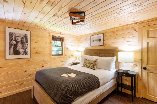 a bedroom with a bed in a wooden cabin at 2 Mi to Dtwn Spacious Gatlinburg Home with Hot Tub! in Gatlinburg