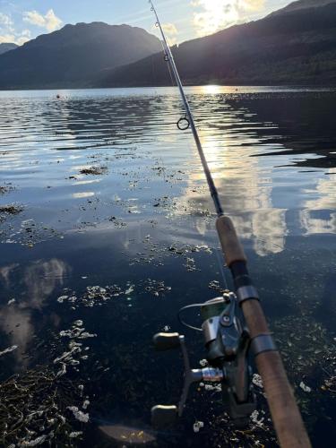a person holding a fishing rod in the water at No4 Invereoch in Arrochar