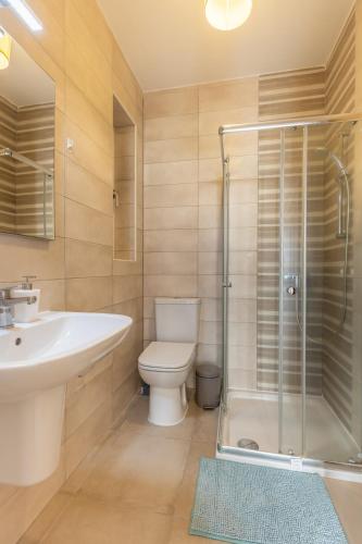 a bathroom with a toilet and a sink and a shower at Private Terrace 3BR Home Near Bay & Promenade by QuickTrips in St. Paul's Bay