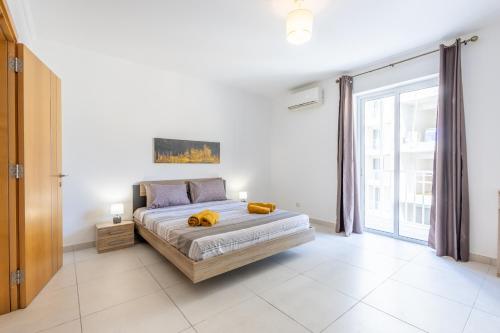 a bedroom with a bed and a large window at Private Terrace 3BR Home Near Bay & Promenade by QuickTrips in St. Paul's Bay
