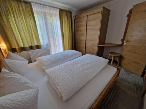 a bedroom with two white beds and a window at Appartement St. Hubertus in Flirsch