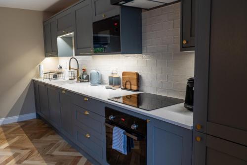 a kitchen with blue cabinets and white counter tops at No4 Invereoch in Arrochar