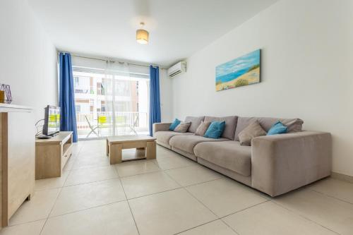 a living room with a couch and a table at Private Terrace 3BR Home Near Bay & Promenade by QuickTrips in St. Paul's Bay