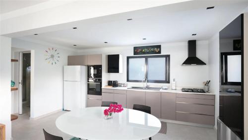 a kitchen with a white table and a white refrigerator at Lorient Beach Retreat with Tropical Garden in Quartier de Lorient