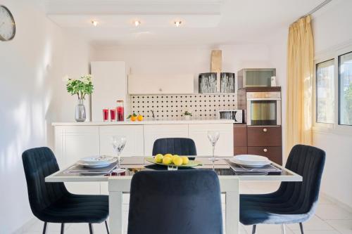 a kitchen with a dining room table with chairs at EVLOGIA HOTEL SEAFRONT and ANEX by Greek Pride in Fourka